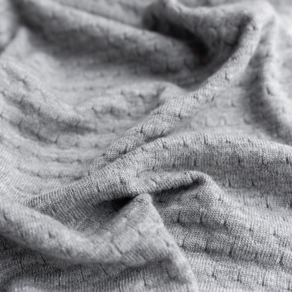 Deken frankie van Hvid, in grey melange, biedt warmte en comfort voor je baby met zacht merino lamswol. Aan twee kanten te gebruiken. Gebruik als deken of wikkeldoek. In twee kleuren. VanZus