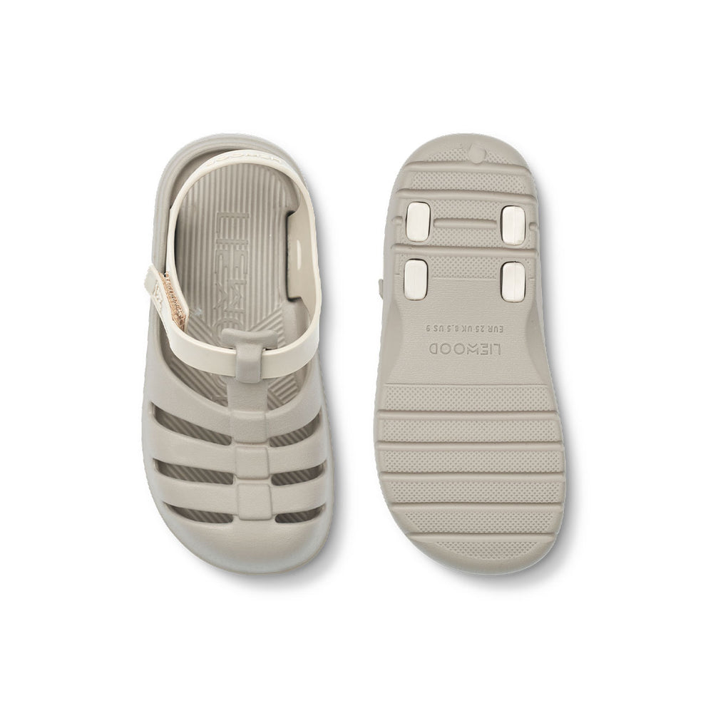Ben je op zoek naar praktische én leuk uitziende sandalen? Dan zijn deze beau sandalen van Liewood in de kleur sandy/mist ideaal! Deze zandkleurige of lichtgrijze waterschoenen zitten namelijk enorm comfortabel, dankzij het zachte en lichtgewicht materiaal, maar zien er ook stijlvol uit. VanZus