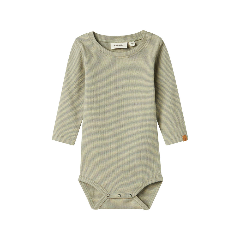 Dit schattige baby feng slim rompertje in de kleur moss gray is een ideaal basic om in huis te halen voor jouw kleine spruit. Dit mooie rompertje van hoge kwaliteit is de ultieme basic voor diverse outfits en zal jouw kleintje gegarandeerd leuk staan! VanZus