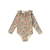 Het Salted Stories sparkly fleurs badpak met lange mouwen beschermt de huid tegen de zon (UPF50+). Het badpak heeft een mooie glitterstof, een print van gekleurde bloemen en ruches aan de bovenkant. VanZus