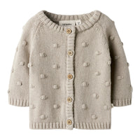 Het baby gable knit vestje in de kleur oxford tan van het merk Lil' Atelier is een must-have voor elke babygarderobe. Dit stijlvolle gebreide vestje, gemaakt van 80% biologisch katoen en 20% gerecycled katoen, biedt niet alleen comfort, maar ook een duurzame keuze.VanZus