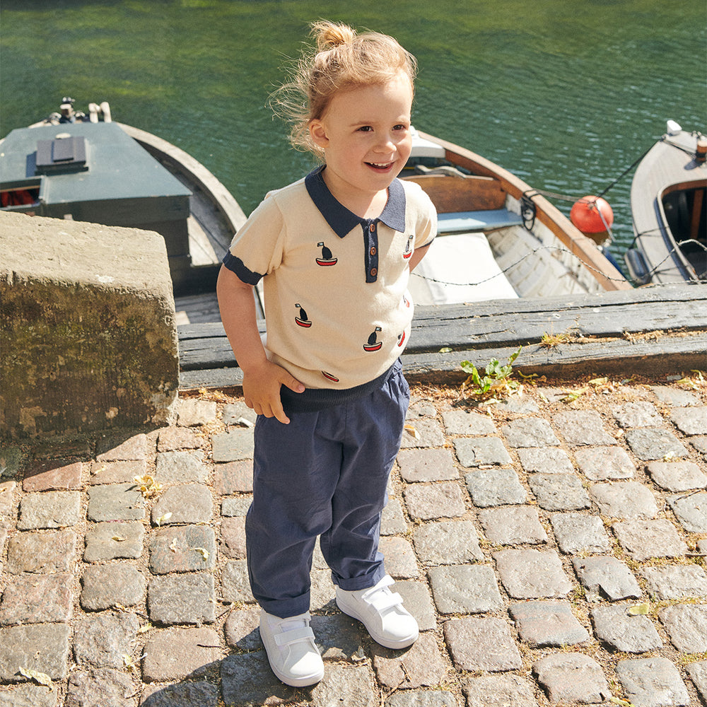 Voor echte sailors: het poloshirt met bootjes in de kleur cream van het Deense merk Copenhagen Colors. Blauwe details, zachte neutrale kleur met een hip motief van boten. Handige knoopjes. In de maten 80 t/m 128. VanZus