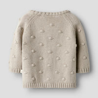 Het baby gable knit vestje in de kleur oxford tan van het merk Lil' Atelier is een must-have voor elke babygarderobe. Dit stijlvolle gebreide vestje, gemaakt van 80% biologisch katoen en 20% gerecycled katoen, biedt niet alleen comfort, maar ook een duurzame keuze.VanZus