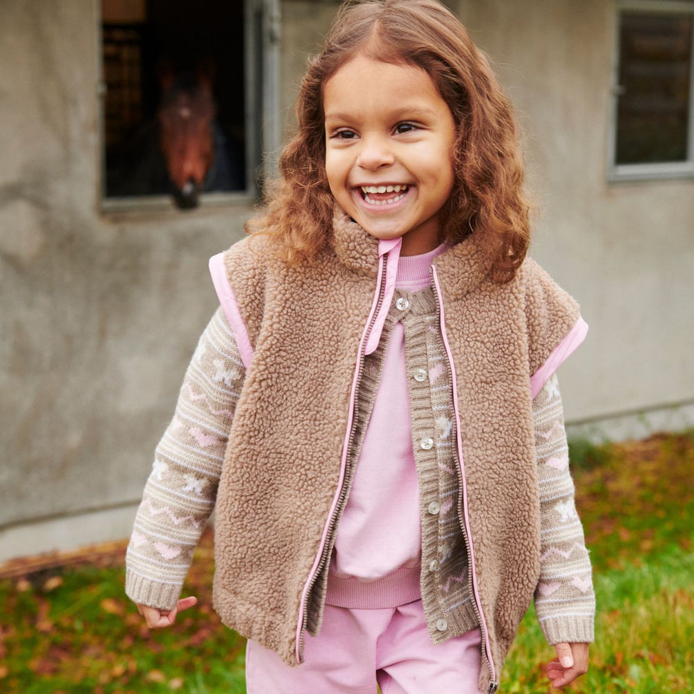 Het Copenhagen Colors cashmere vestje sand is een fijn gebreid vestje in beige met witte en roze accenten. De knoopjes aan de voorkant maken het makkelijk om aan te trekken. VanZus