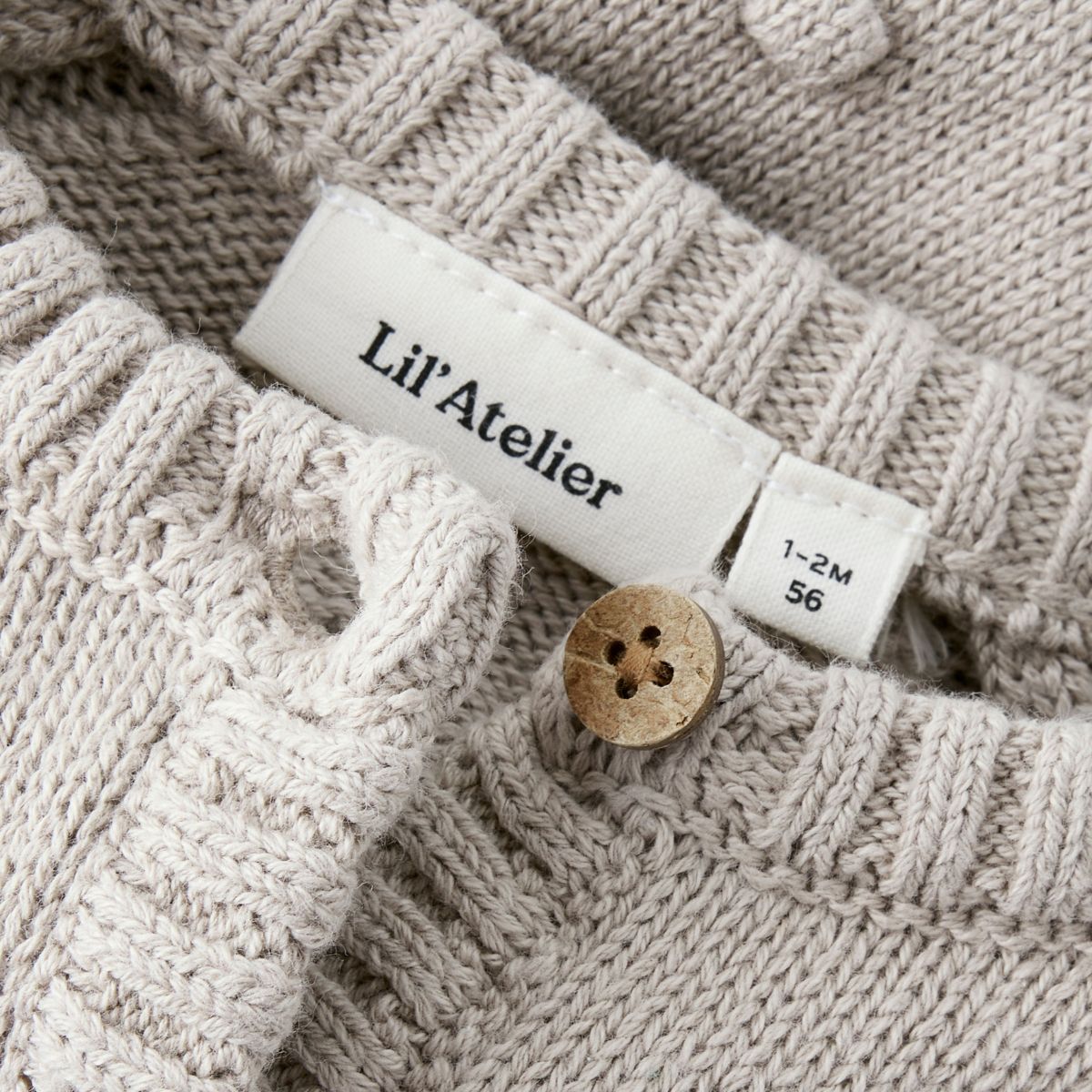 Het baby gable knit vestje in de kleur oxford tan van het merk Lil' Atelier is een must-have voor elke babygarderobe. Dit stijlvolle gebreide vestje, gemaakt van 80% biologisch katoen en 20% gerecycled katoen, biedt niet alleen comfort, maar ook een duurzame keuze.VanZus