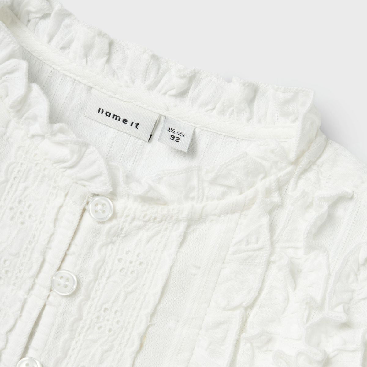 Hoe lief is dit hellia blousje in de kleur bright white van het merk Name It?! Dit schattige blousje is ideaal om romantische outfits mee te maken en zal je kindje ontzettend schattig staan! Het blousje heeft een witte kleur en heeft verschillende lieflijke details. VanZus