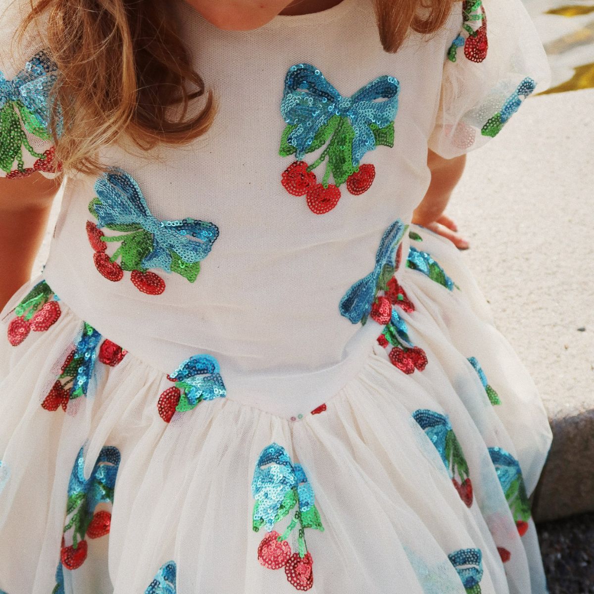 Roze met glitters én kersjes?! De heartlily jurk met pailletten in de kleur amarena sequin van het merk Konges Slojd is een absolute showstopper! Deze jurk is helemaal bezaaid met glinsterende kersen. VanZus