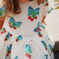 Roze met glitters én kersjes?! De heartlily jurk met pailletten in de kleur amarena sequin van het merk Konges Slojd is een absolute showstopper! Deze jurk is helemaal bezaaid met glinsterende kersen. VanZus