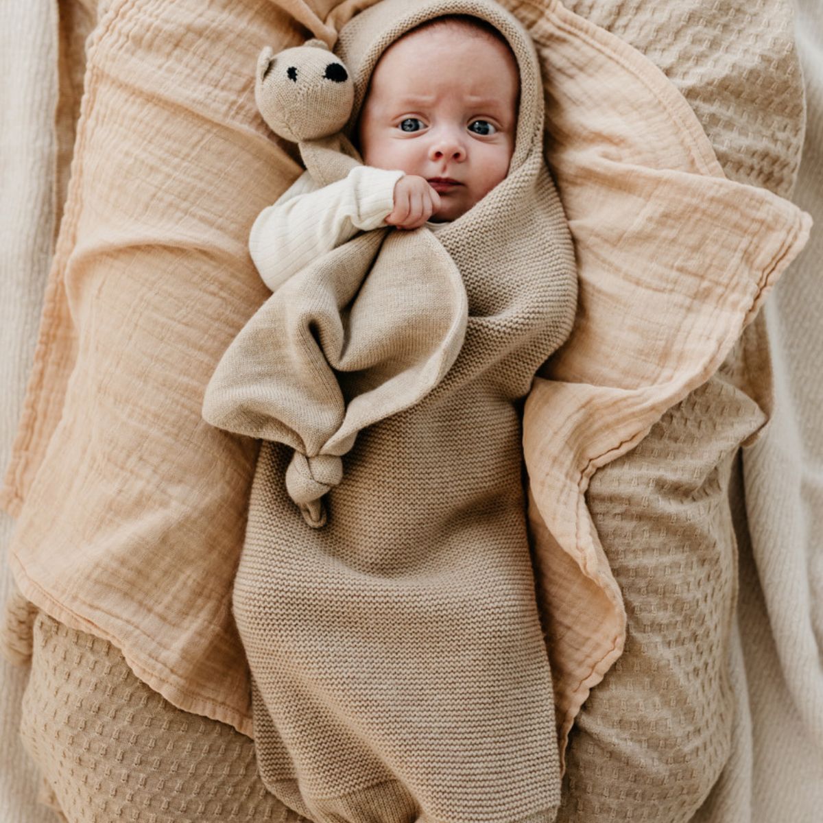 Deken frankie van Hvid, in sand, biedt warmte en comfort voor je baby met zacht merino lamswol. Aan twee kanten te gebruiken. Gebruik als deken of wikkeldoek. In twee kleuren. VanZus