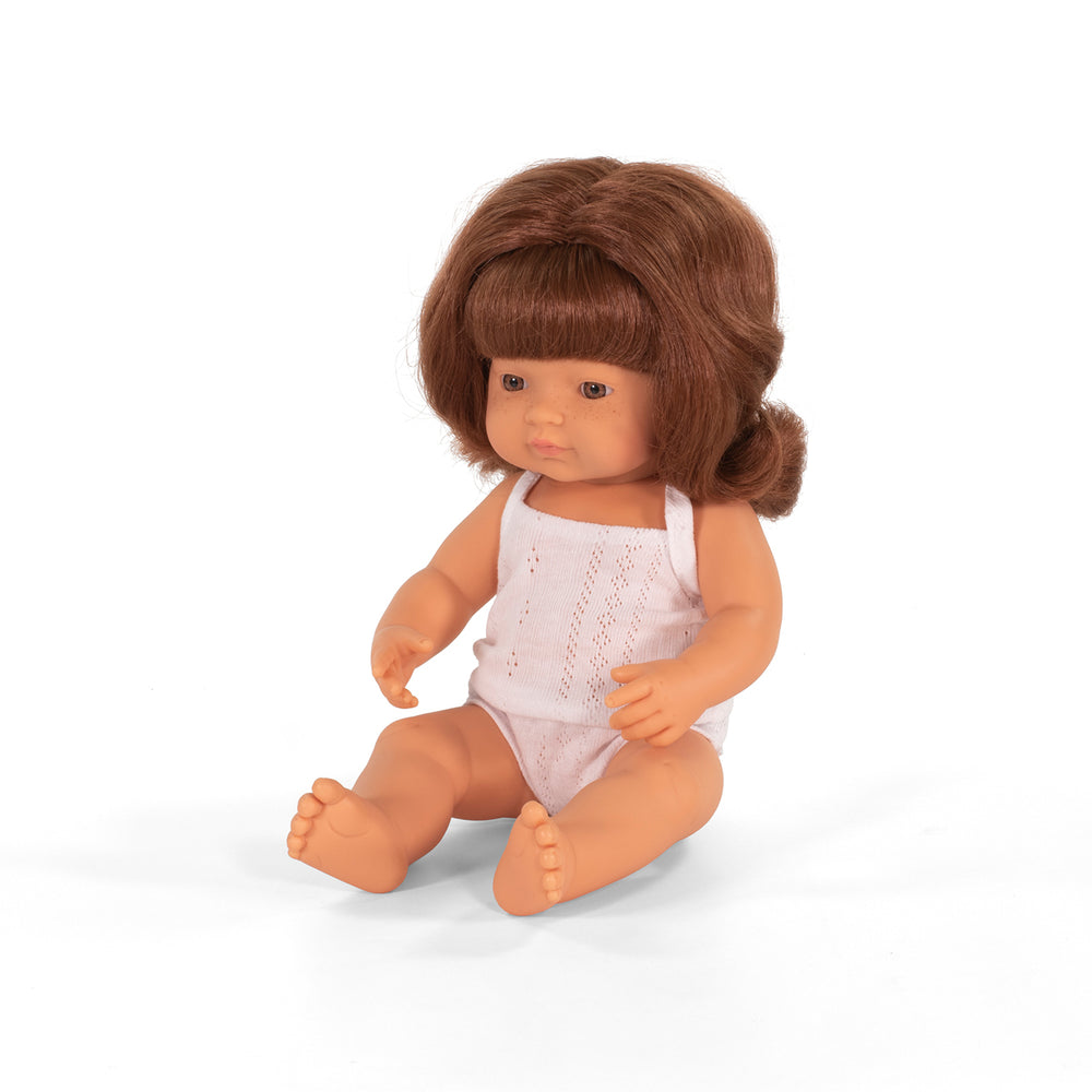 Wat een schatje: de babypop Europees meisje met rood haar van Miniland. Een zacht lijfje met beweegbare armen en benen. Ruikt naar een vleugje vanille. Kleed de pop zelf aan. In verschillende soorten. 38 cm. VanZus