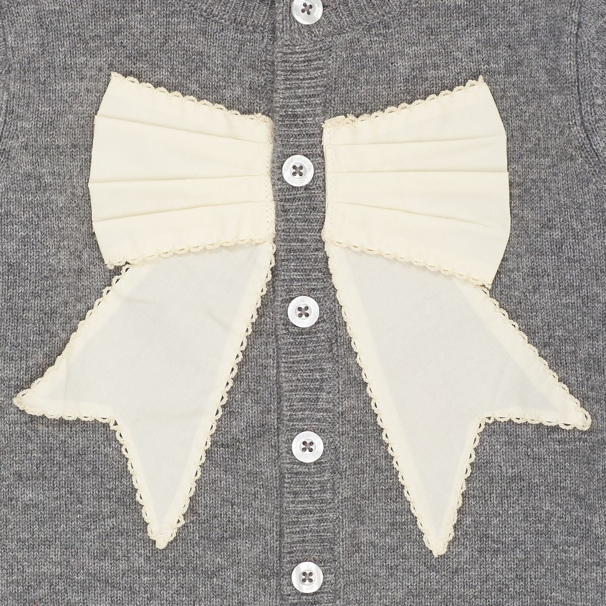 Het Copenhagen Colors cashmere vestje poplin bow dark grey melange/cream is een warme laag met een klassiek accent. De grijze kleur vormt een mooi contrast met de witte strik aan de voorkant. VanZus