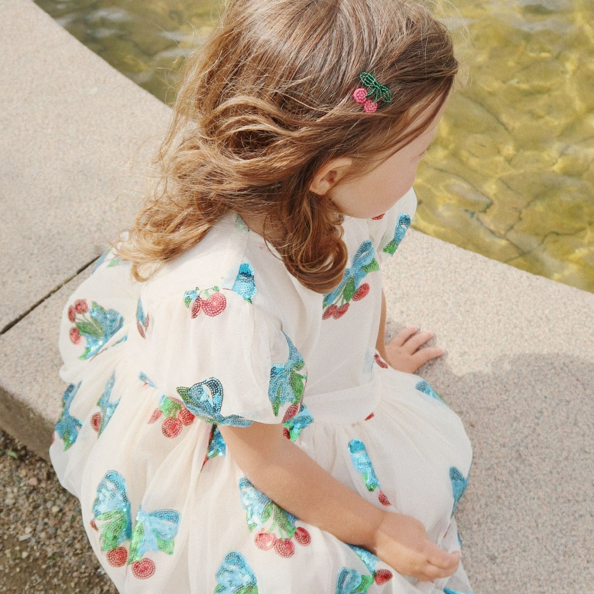 Roze met glitters én kersjes?! De heartlily jurk met pailletten in de kleur amarena sequin van het merk Konges Slojd is een absolute showstopper! Deze jurk is helemaal bezaaid met glinsterende kersen. VanZus