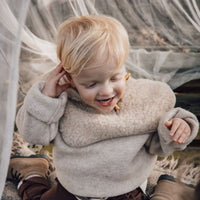 De Alwero hoodik balaclava button beige is hét perfecte accessoire voor alle kleine koukleumen. Staat jouw kindje ook altijd buiten te bibberen wanneer het waait of sneeuwt? Dan is muts en sjaal in 1 perfect! VanZus.