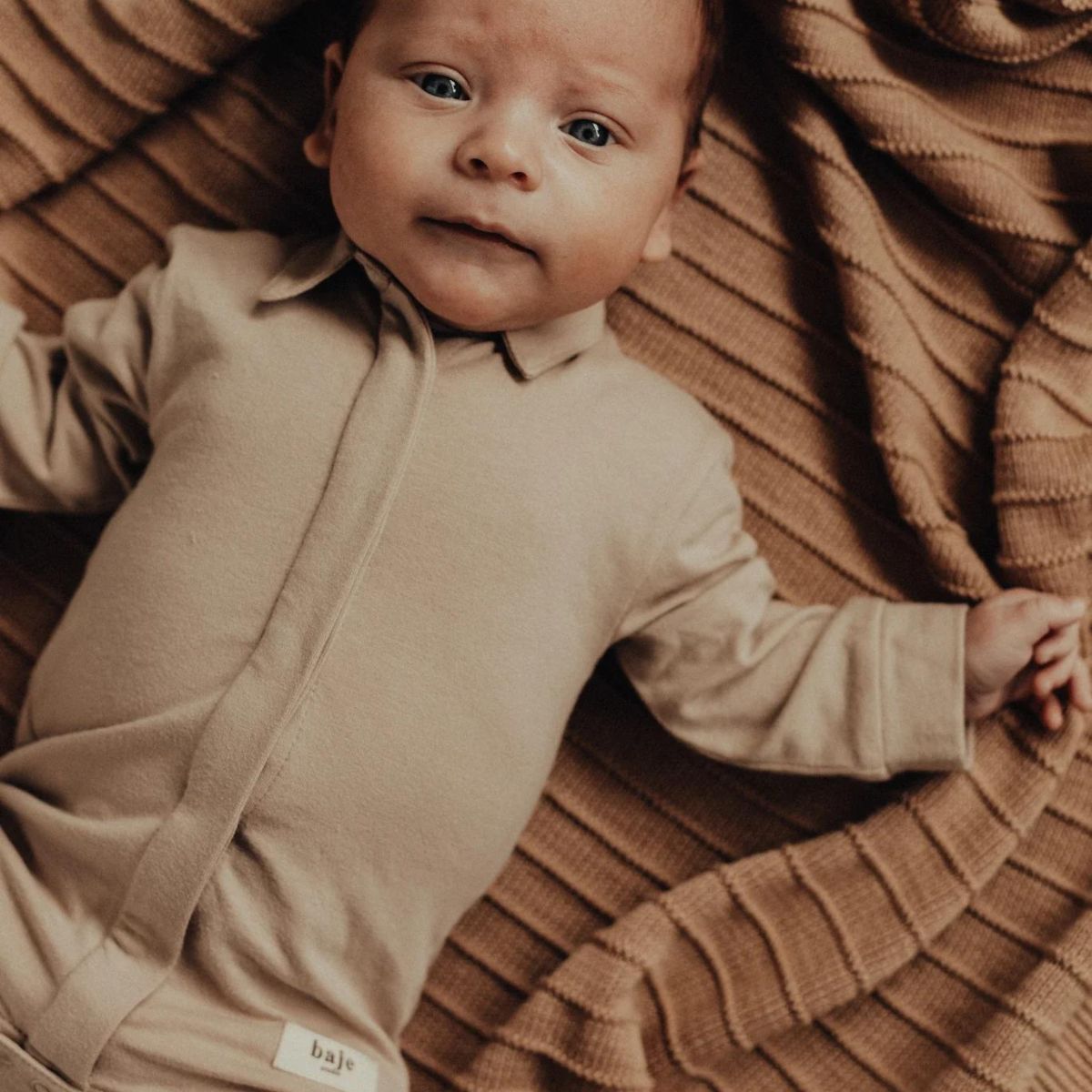 Het Baje Studio owen newborn rompershirt in de kleur peanut is een prachtige romper in de stijl van een polo. Het enige wat je hoeft toe te voegen is een leuk broekje en je kleine is klaar voor de dag. VanZus.