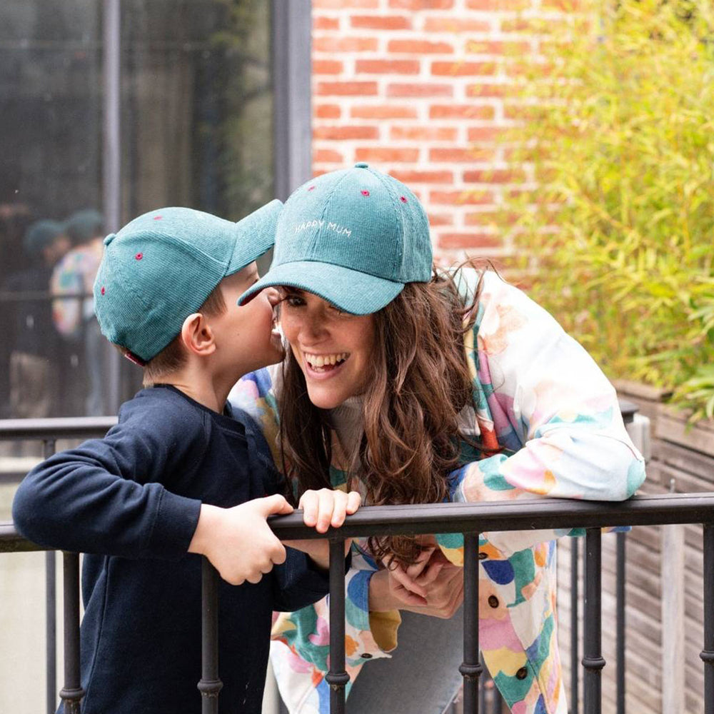 Houd je hoofd beschermd tegen de zon met deze te leuke velours cap happy mum van het merk Chamaye. Deze pet is ideaal voor wanneer het buiten zonnig is of wanneer je simpelweg een bad hair day hebt. De pet heeft een prachtige, blauwe corduroy stof, wat de pet een luxe uitstraling geeft. VanZus