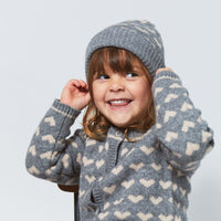 Een warm koppie en warme oortjes én er ook nog stylish uitzien? Dat komt helemaal goed met deze kasjmier beanie muts hearts & pompom in de kleur grey melange/taupe van het merk Copenhagen Colors. VanZus