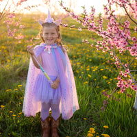 Betreed een wereld van betovering en kleur met deze regenboog unicorn cape met hoofdband van het merk Great Pretenders. Met deze twee te lieve accessoires verandert jouw kleine spruit zo in een magische eenhoorn. VanZus