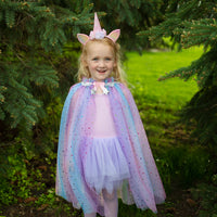 Betreed een wereld van betovering en kleur met deze regenboog unicorn cape met hoofdband van het merk Great Pretenders. Met deze twee te lieve accessoires verandert jouw kleine spruit zo in een magische eenhoorn. VanZus