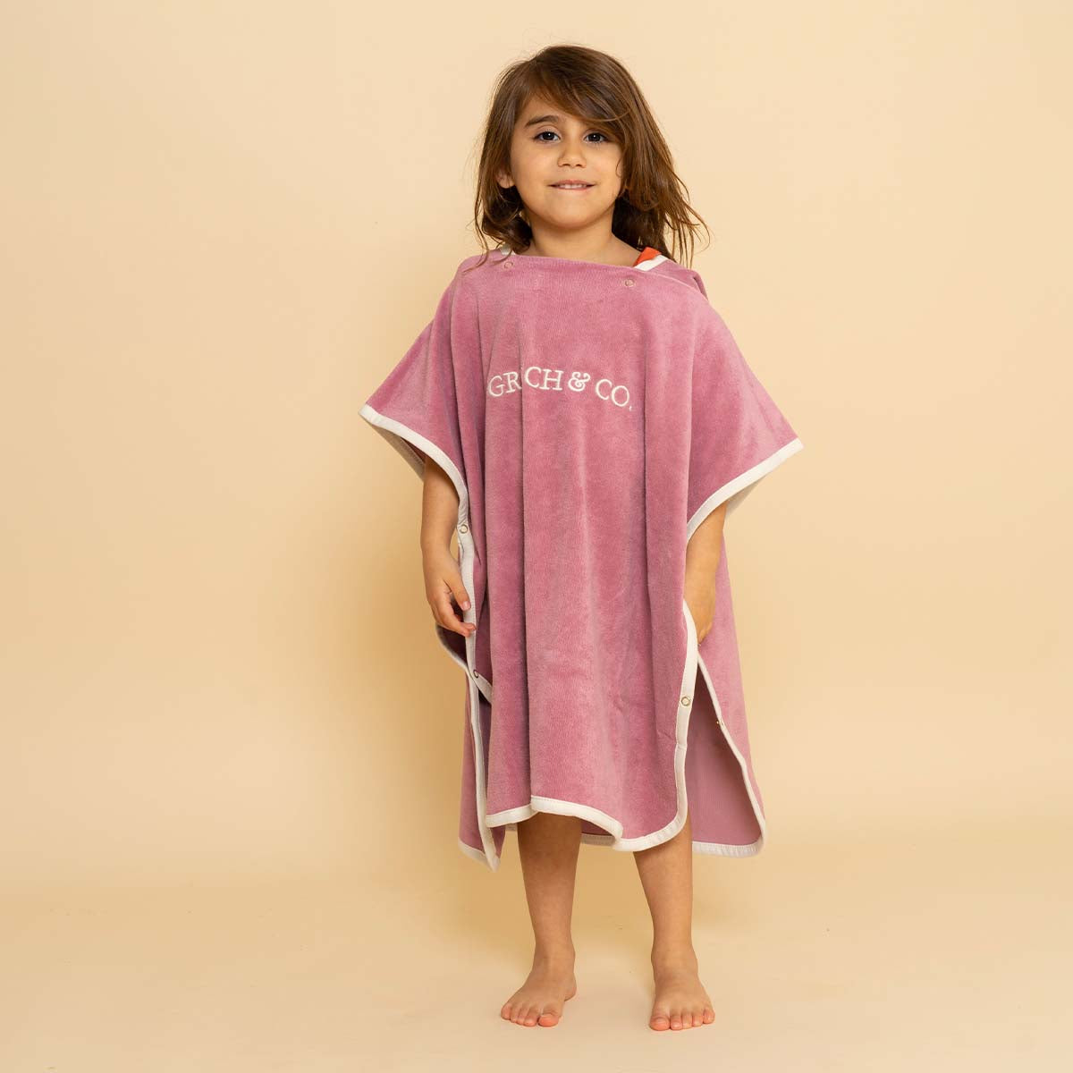 Na het badje, strand of zwembad pak je je kindje heerlijk warm in met de badponcho mauve rose van Grech & Co. Opdrogen, warm worden en comfortabel zijn. De badcape heeft een capuchon en drukknoopjes. VanZus