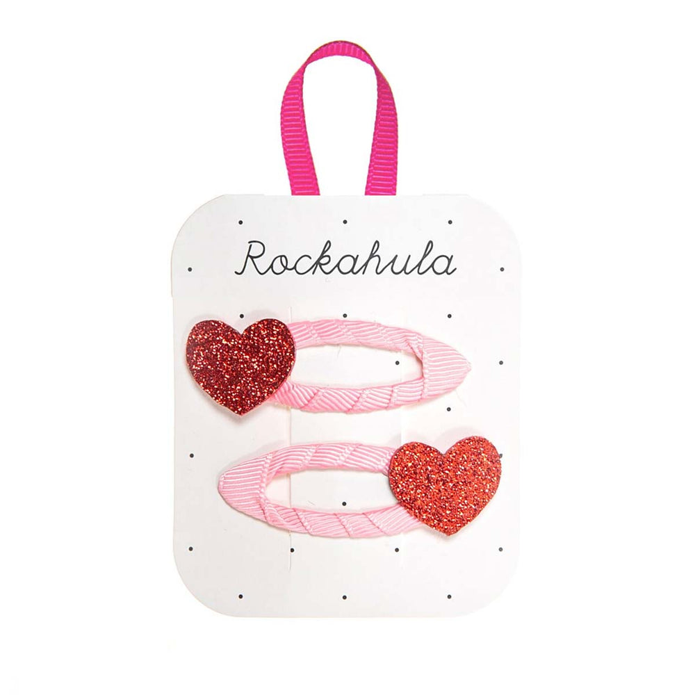 Love is in the air met Rockahula’s love heart glitter speldjes! De set bestaat uit 2 speldjes, omwikkeld met roze grosgrain lint en versierd met rode schitterende hartjes. Hip en handig! VanZus