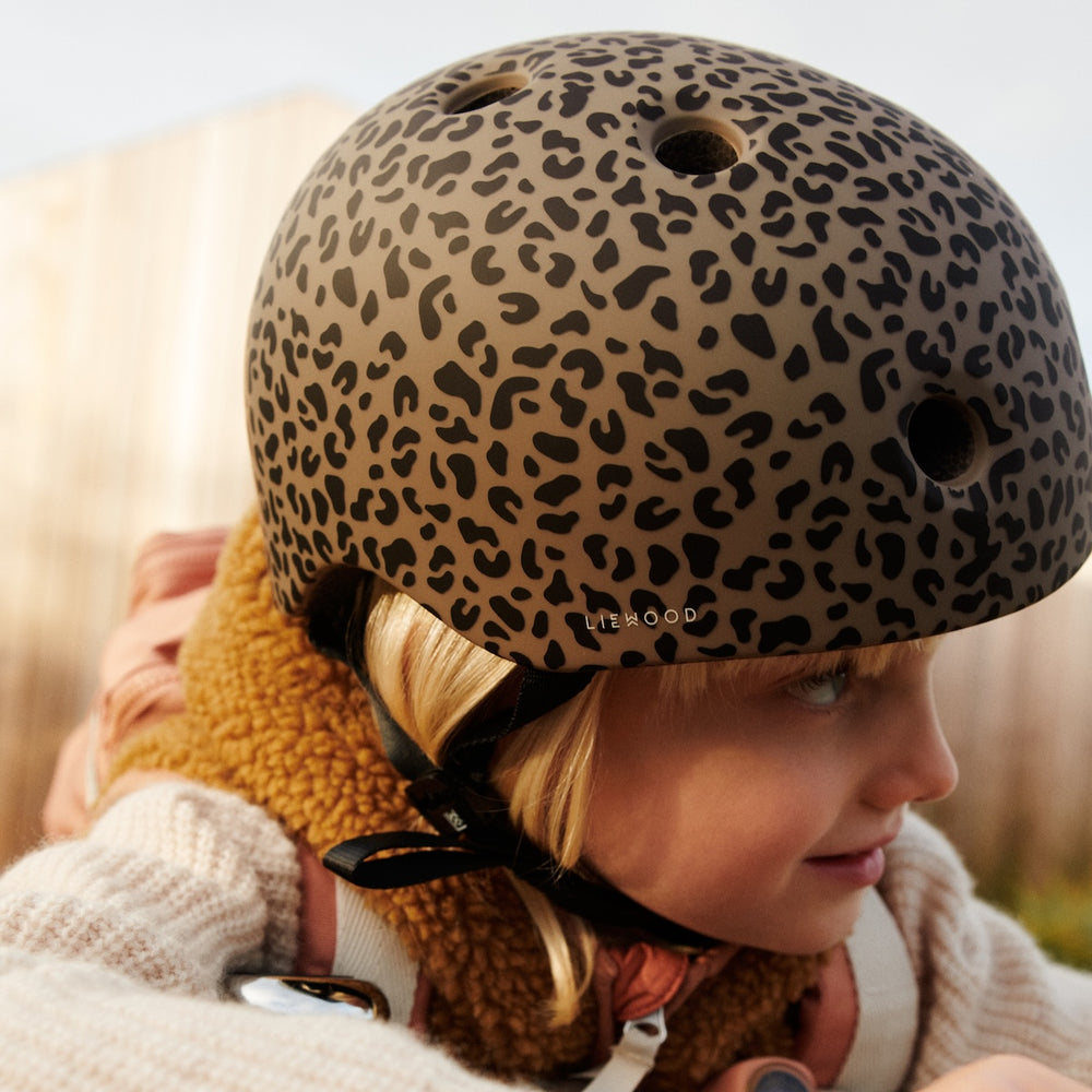 Veiligheid en stijl gaan hand in hand met deze toffe fietshelm in de kleur mini leo/oat van het merk Liewood. Deze helm is ontworpen om niet alleen bescherming te bieden tijdens avontuurlijke fietstochten, maar ook om er stijlvol uit te zien tijdens het fietsen! VanZus