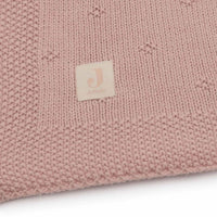 De cosy knit deken in wild rose van het merk Jollein is een luxe, gebreide deken van 100% katoen. Perfect voor het ledikant (100x150 cm) en biedt warmte en stijl in de babykamer. Ook in andere kleuren. VanZus