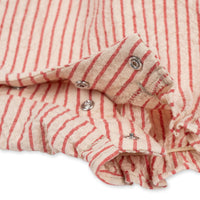 Op zoek naar een schattige romper voor je baby? Dan is de ellie ruches romper amour stripe van Konges Slojd een perfecte keuze.  De gestreepte romper heeft een rode kleur en een print van een kers op de voorzijde. De mouwen en het voorpand zijn afgewerkt met ruches en de romper heeft korte elastische pijpen.