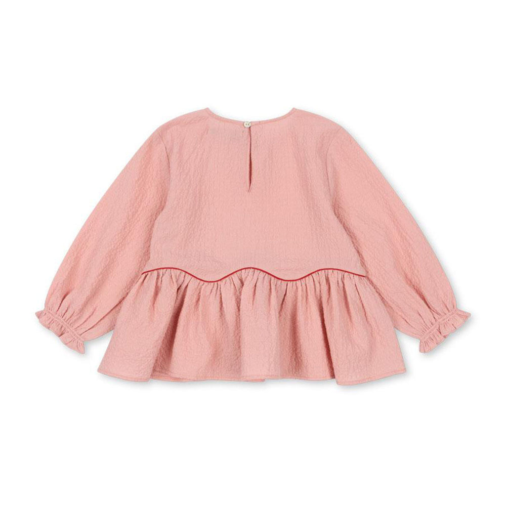 Zowel jij als je dochter zullen absoluut verliefd worden op deze mooie ava blouse in de kleur mellow rose van het merk Konges Slojd. Deze prachtige roze blouse is het perfecte item voor meiden die houden van romantiek en flair. VanZus