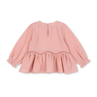 Zowel jij als je dochter zullen absoluut verliefd worden op deze mooie ava blouse in de kleur mellow rose van het merk Konges Slojd. Deze prachtige roze blouse is het perfecte item voor meiden die houden van romantiek en flair. VanZus