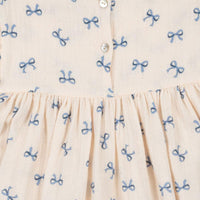 De coco jurk bow bleu van het Deense merk Konges Slojd is een betoverende keuze voor je kleintje. Deze schattige jurk in een neutrale witte kleur is gemaakt van ademende en lichte mousseline, perfect voor warme dagen. VanZus