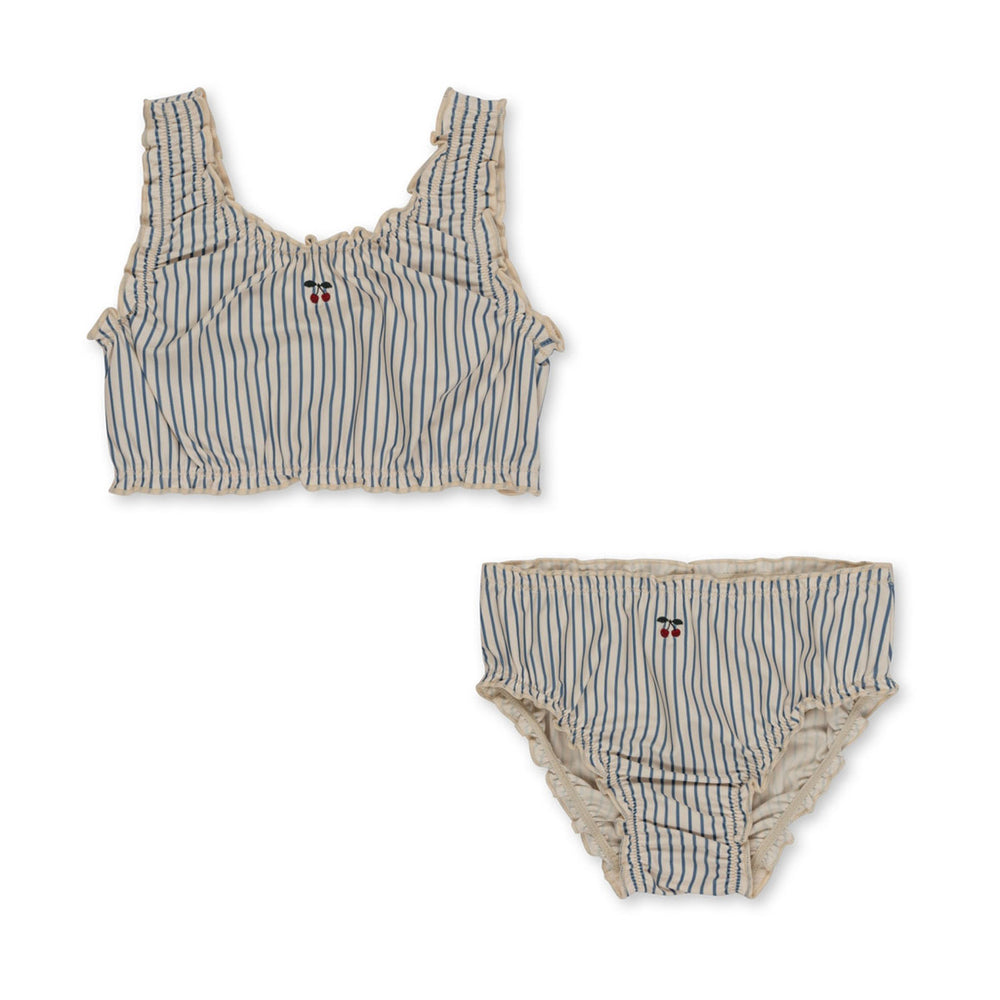 Deze heerlijke Konges Slojd collette bikini blue stripe is ideaal voor jouw kleine spruit wanneer jullie gezellig gaan zwemmen, naar het strand gaan of voor op vakantie! In deze bikini ziet jouw kleintje er superschattig uit!  De bikini heeft een mooie witte kleur en heeft schattige blauwe streepjes. VanZus