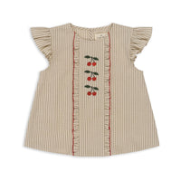 De mooie ellie ruches top in de kleur tea stripe van Konges Slojd heeft door de details een bijzondere uitstraling. De seersucker blouse heeft schattige kersjes, strepen en ruffles waardoor het erg mooi zal staan bij jouw kindje. VanZus