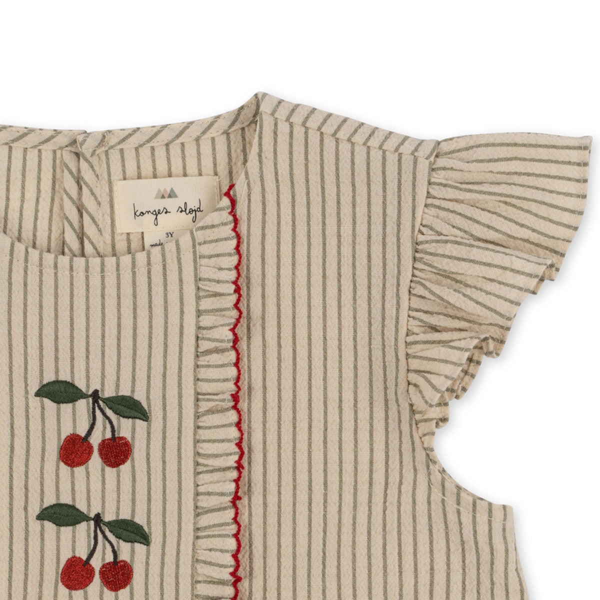 De mooie ellie ruches top in de kleur tea stripe van Konges Slojd heeft door de details een bijzondere uitstraling. De seersucker blouse heeft schattige kersjes, strepen en ruffles waardoor het erg mooi zal staan bij jouw kindje. VanZus