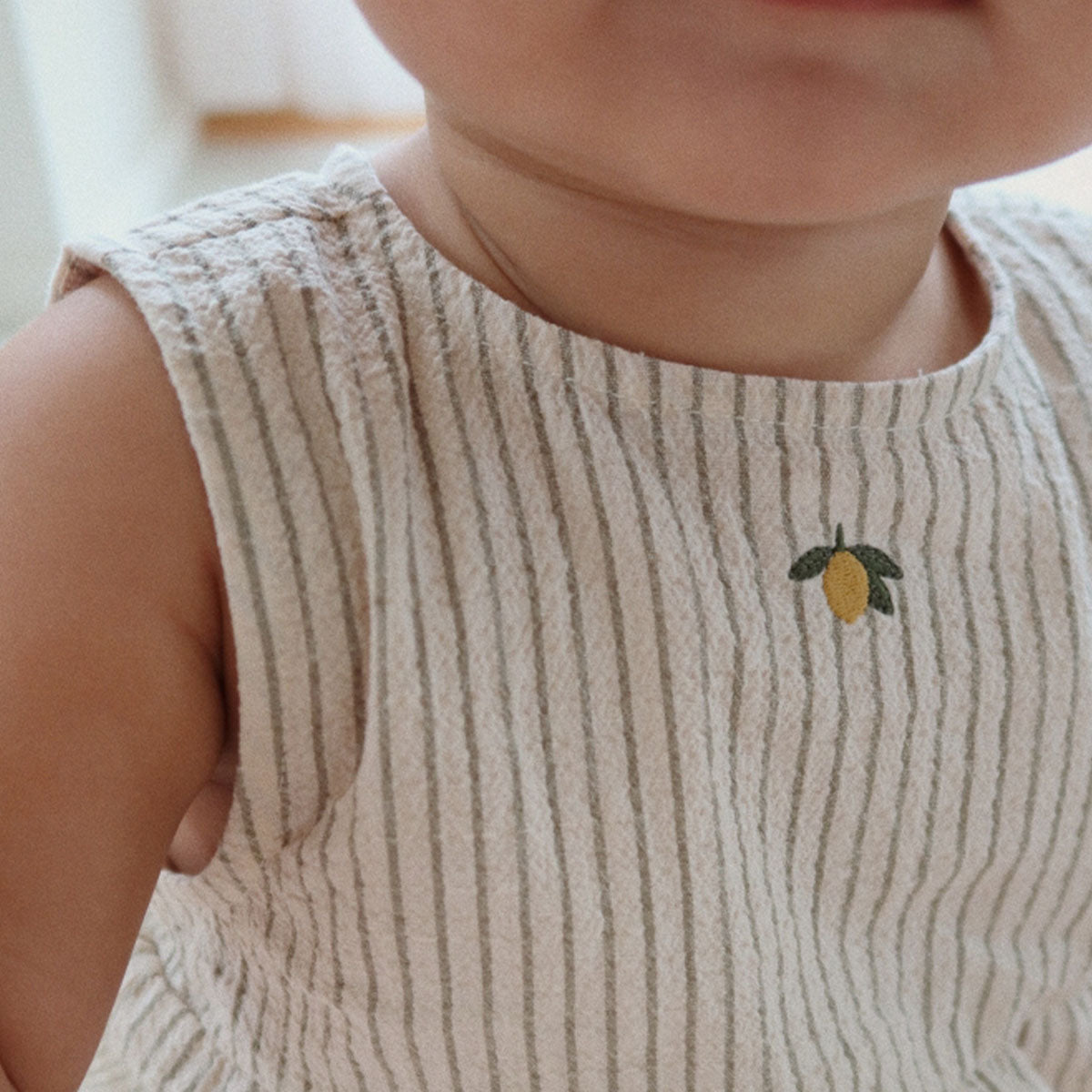 Op zoek naar een bijzondere, maar neutrale romper voor je baby? Dan is de elliot romper tea stripe van Konges Slojd een perfecte keuze.  De gestreepte romper heeft een neutrale kleur en een citroen op de voorzijde. Het rompertje is gemaakt van een zachte seersucker stof van 98% organisch katoen met 2% elastaan. 