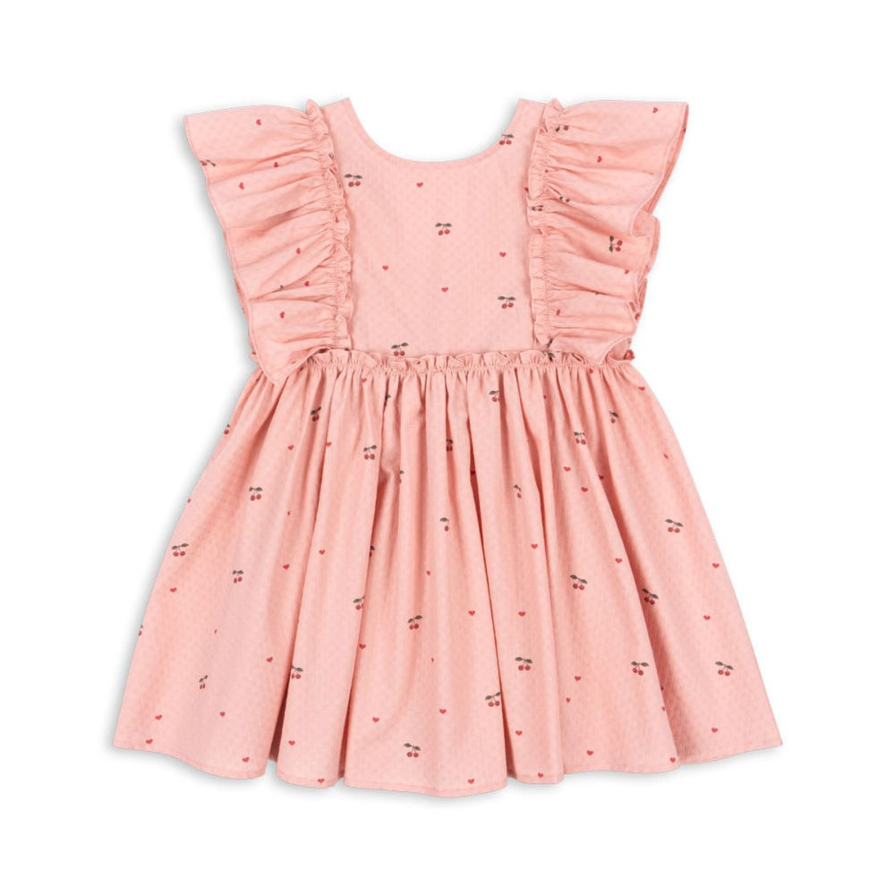 Hoe schattig is deze evia bow jurk in de variant cherry coeur van het merk Konges Slojd? Dit mooie jurkje met een roze kleur en een schattige kersenprint is het ideale jurk voor zowel feestelijke gelegenheden als alledaagse outfits. De jurk is gemaakt van 100% organisch katoen en heeft ruches bij de mouwen en een wijd uitlopende rok. VanZus