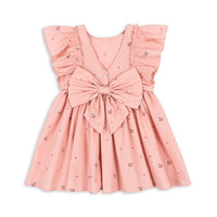 Hoe schattig is deze evia bow jurk in de variant cherry coeur van het merk Konges Slojd? Dit mooie jurkje met een roze kleur en een schattige kersenprint is het ideale jurk voor zowel feestelijke gelegenheden als alledaagse outfits. De jurk is gemaakt van 100% organisch katoen en heeft ruches bij de mouwen en een wijd uitlopende rok. VanZus