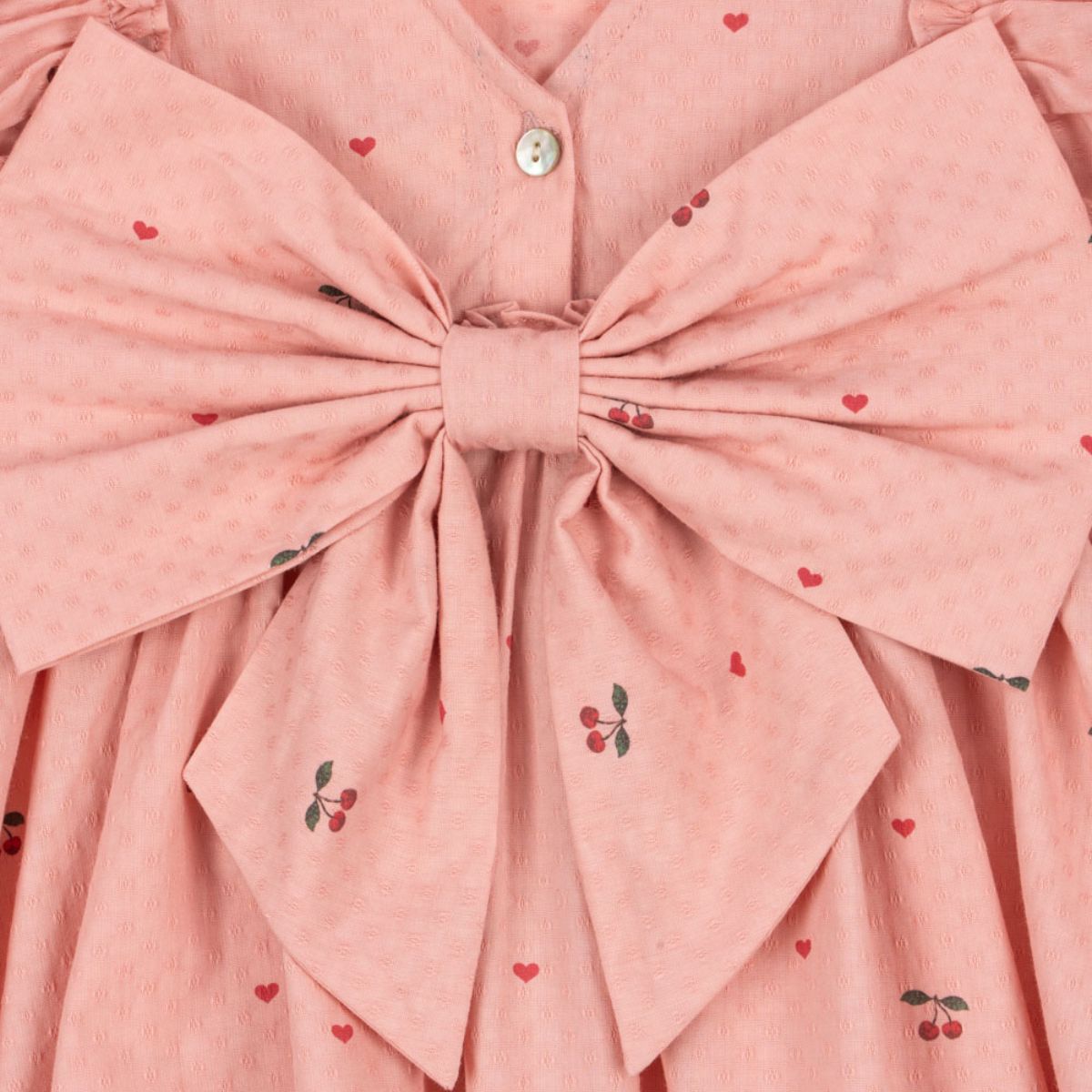 Hoe schattig is deze evia bow jurk in de variant cherry coeur van het merk Konges Slojd? Dit mooie jurkje met een roze kleur en een schattige kersenprint is het ideale jurk voor zowel feestelijke gelegenheden als alledaagse outfits. De jurk is gemaakt van 100% organisch katoen en heeft ruches bij de mouwen en een wijd uitlopende rok. VanZus