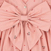 Hoe schattig is deze evia bow jurk in de variant cherry coeur van het merk Konges Slojd? Dit mooie jurkje met een roze kleur en een schattige kersenprint is het ideale jurk voor zowel feestelijke gelegenheden als alledaagse outfits. De jurk is gemaakt van 100% organisch katoen en heeft ruches bij de mouwen en een wijd uitlopende rok. VanZus