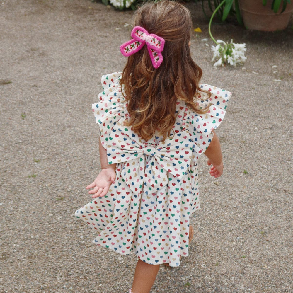 Hoe schattig is deze evia bow jurk in de variant coeur coloré van het merk Konges Slojd? Dit mooie jurkje met een beige kleur en een schattige print van gekleurde hartjes is het ideale jurk voor zowel feestelijke gelegenheden als alledaagse outfits. VanZus