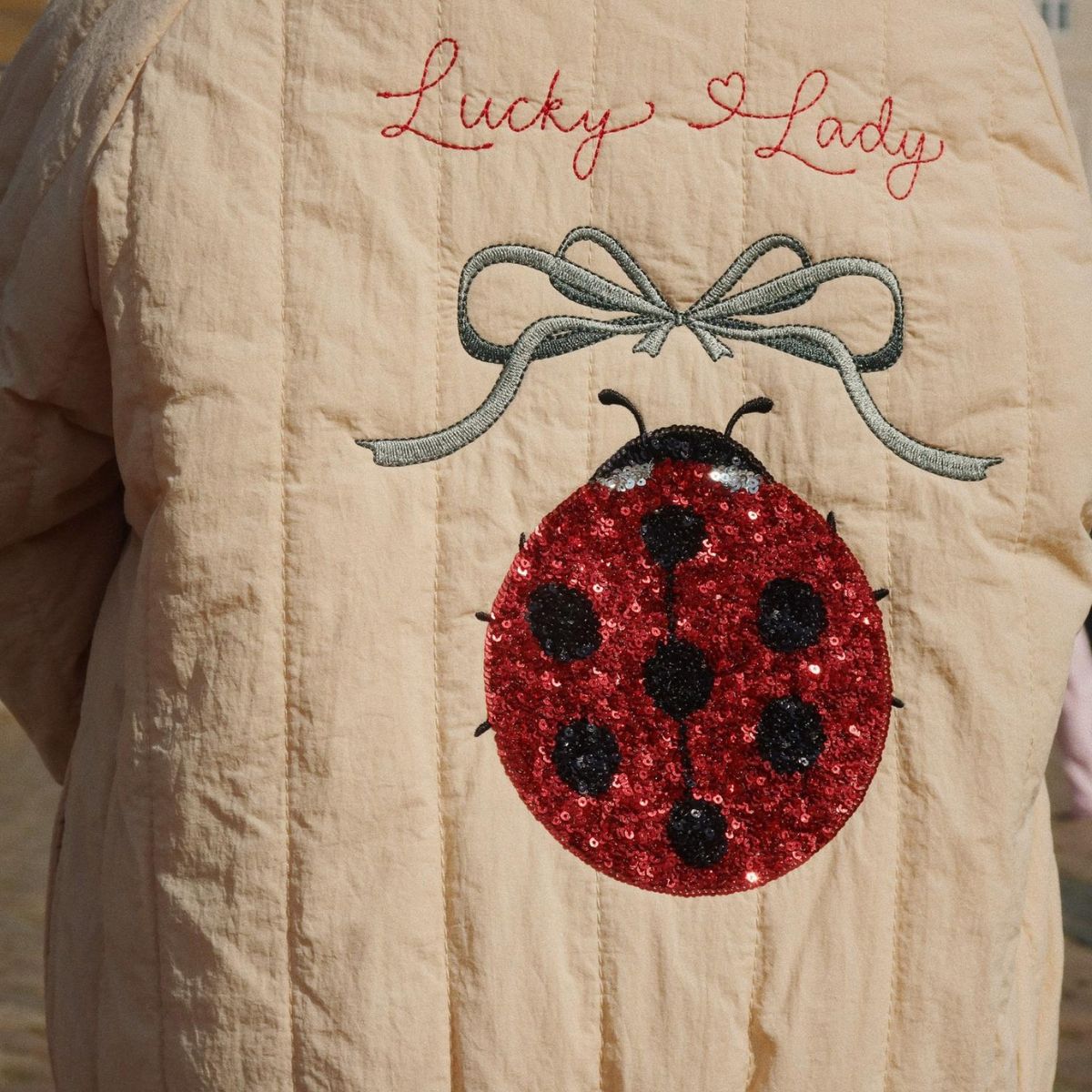 Je kindje steelt de show met dit stoere Konges Slojd juno sequin bomber jas in de variant frappé. Dit leuke zandkleurige bomberjack heeft een schattig lieveheersbeestje en de tekst 'lucky lady' op de achterkant neemt je mee terug naar je eigen kindertijd. VanZus