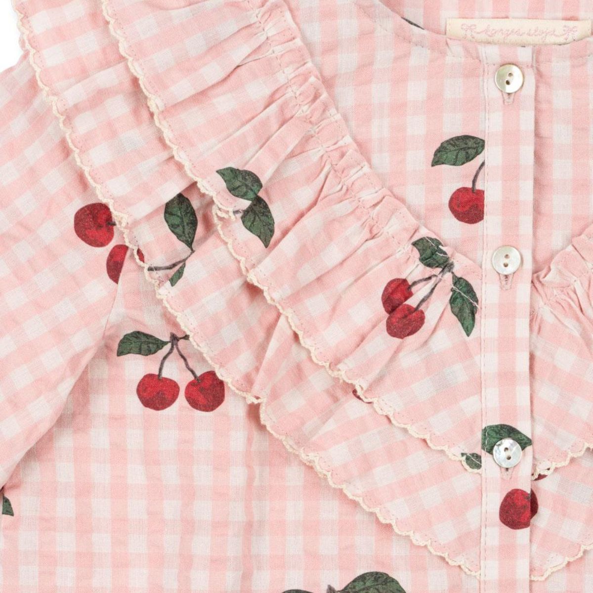 De Konges Slojd kim ruches blouse cherry check is een stijlvolle toevoeging aan de kindergarderobe. Gemaakt van zacht, biologisch katoen met schattige ruches en kersenprint, perfect voor elke gelegenheid! VanZus