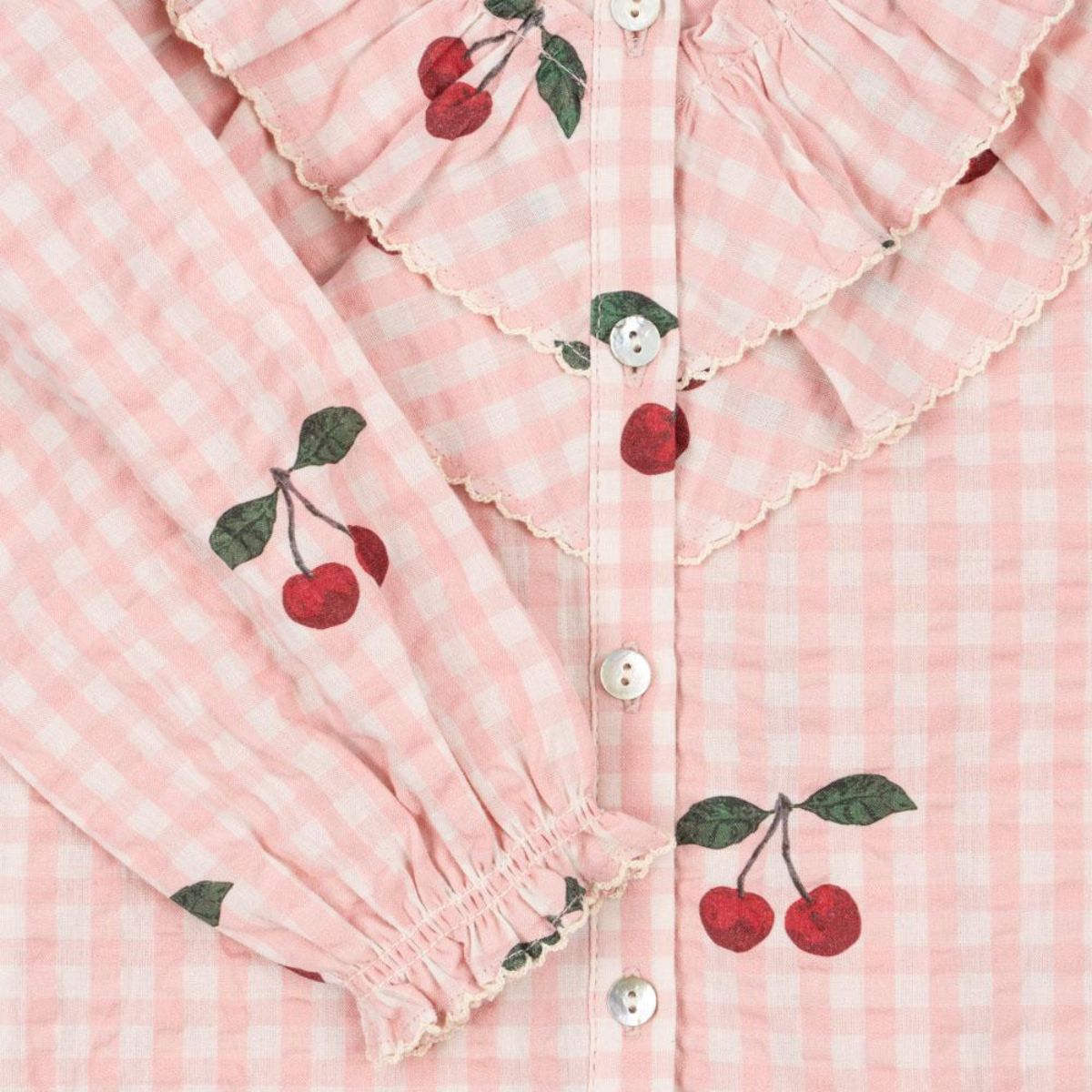 De Konges Slojd kim ruches blouse cherry check is een stijlvolle toevoeging aan de kindergarderobe. Gemaakt van zacht, biologisch katoen met schattige ruches en kersenprint, perfect voor elke gelegenheid! VanZus