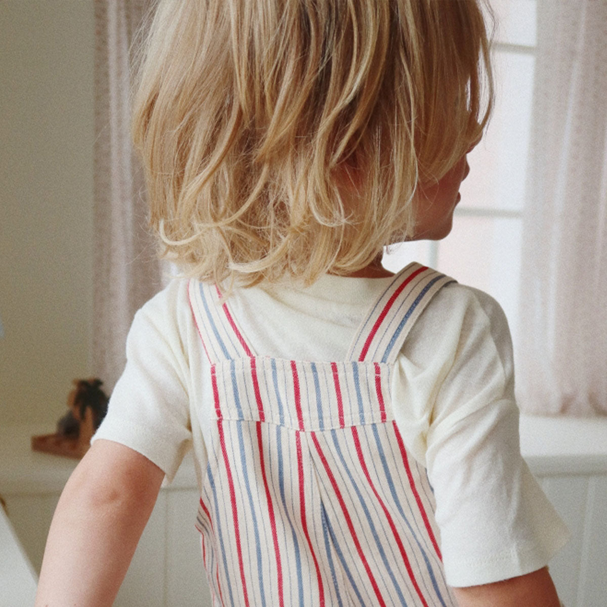 Hoe schattig is deze hippe marlon tuinbroek in de print antique stripe van Konges Slojd?! Het tuinpakje heeft korte pijpjes en is voorzien van een mooie print van gekleurde verticale strepen in rood en blauw voor een vintage look. VanZus