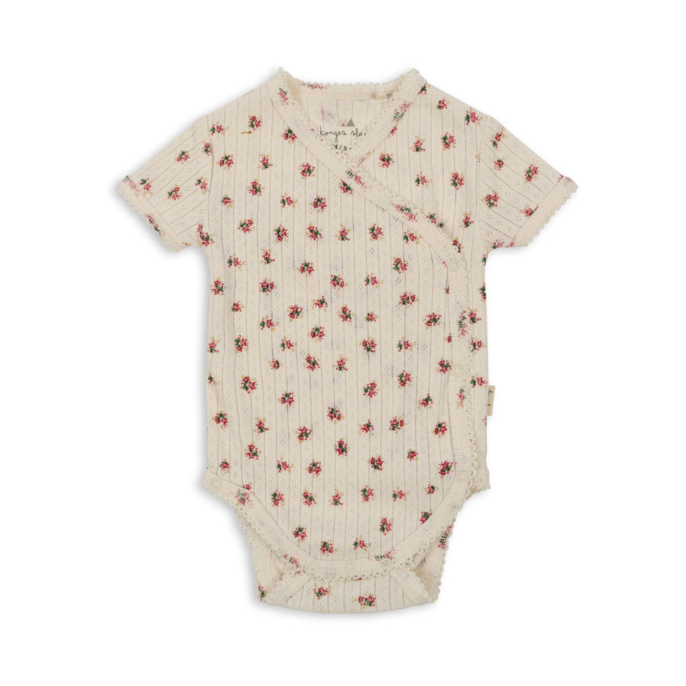 Ben je op zoek naar een heerlijk zachte romper voor jouw newborn? Dan is deze minnie newborn romper met korte mouwen met de schattige print bloomie van Konges Slojd zeker een must have voor in de kledingkast! De romper heeft een handig overslagmodel en drukknoopjes aan de zij- en onderkant.