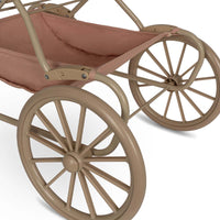 De Konges Slojd poppenwagen mahogany rose heeft een vintage look en is ontworpen met vier grote wielen gemaakt van EVA materiaal voor extra stabiliteit. De kinderwagen voor poppen heeft mooie roze kleur en een kersje op de voorkant. VanZus