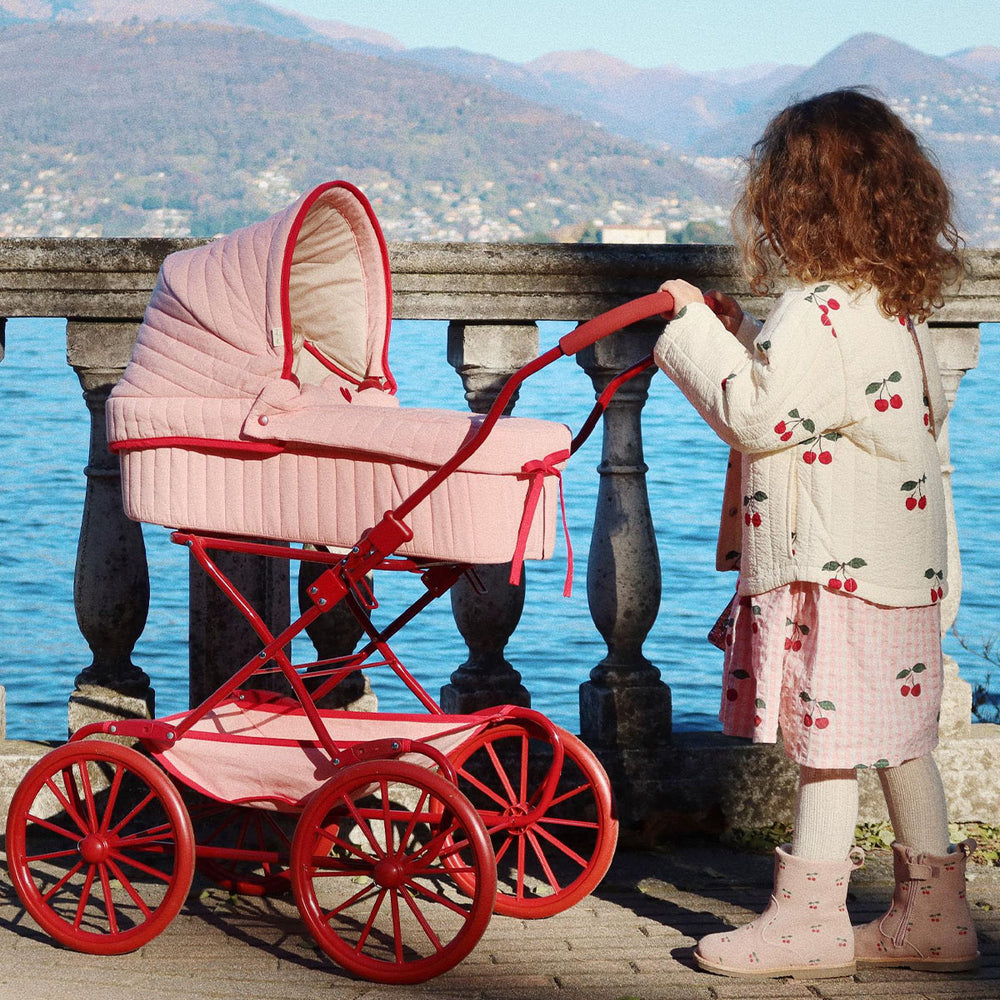 De Konges Slojd poppenwagen mellow rose heeft een vintage look en is ontworpen met vier grote wielen gemaakt van EVA materiaal voor extra stabiliteit. De poppenwagen is gemaakt van gewatteerde bedrukte stof en wordt geleverd met een matras. VanZus