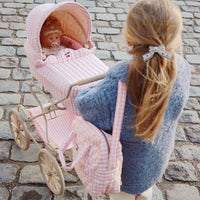 De Konges Slojd poppenwagen in powder pink check heeft een vintage look en is ontworpen met vier grote wielen gemaakt van EVA materiaal voor extra stabiliteit. De kinderwagen voor poppen heeft een schattig ruitjespatroon. VanZus