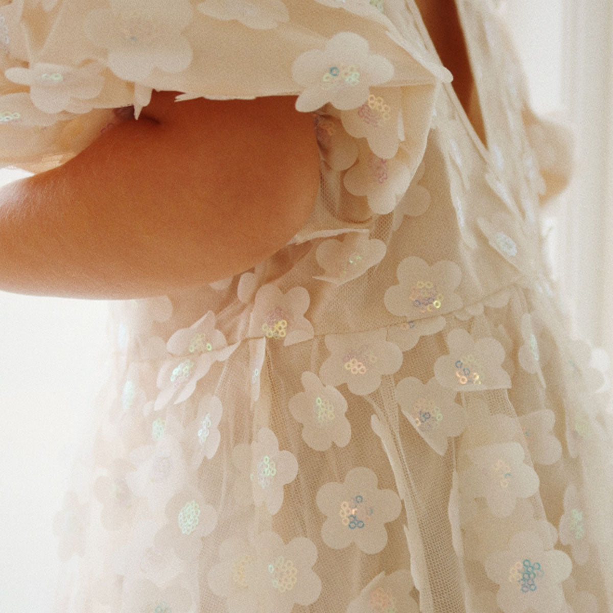 Wat een plaatje is de sally jurk pearled ivory van Konges Slojd!  Deze tulen jurk met pofmouwen en opening op de rug is bezaaid met opgestikte bloemen en pailletten. Een geweldige jurk voor een communie, een bruiloftsjurk (zelfs als je dochter bruidsmeisje mag zijn) of feestjurk! VanZus