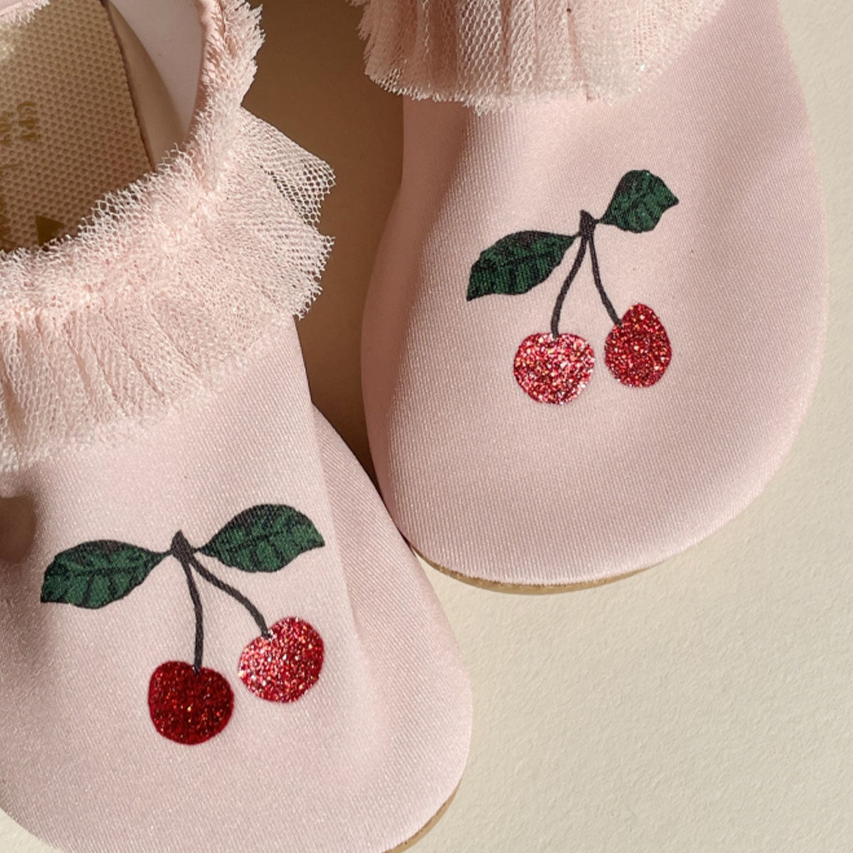 De perfecte zwemschoentjes voor deze zomer! Deze Konges Slojd strut zwemschoenen in cameo rose beschermen de voetjes van je kleintje op het strand of in het zwembad en voorkomen uitglijden. De leuke roze waterschoenen voor meisjes zijn versierd met schattige kersen en hebben glinsterend tule als leuke detail.