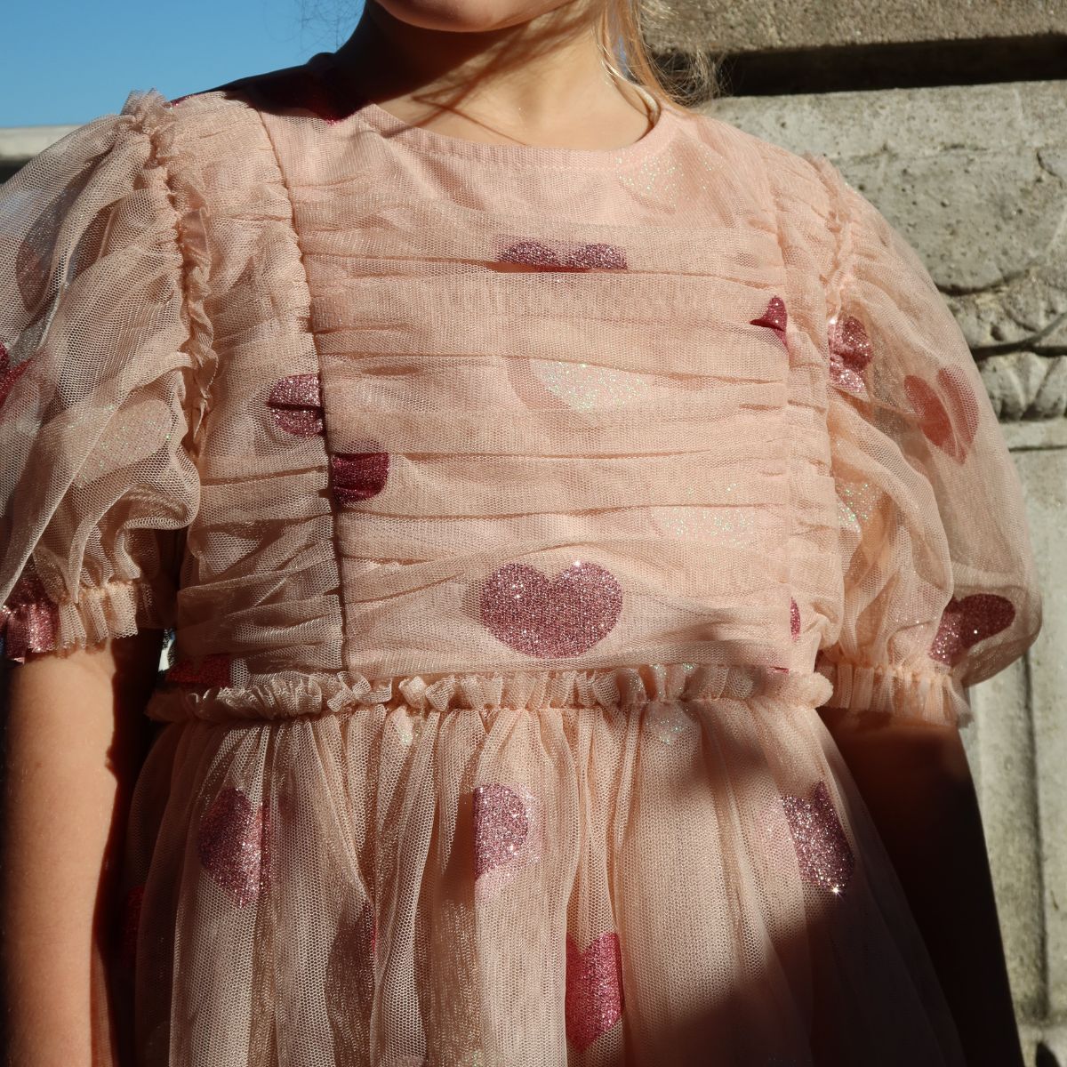 Wat een plaatje is de tullie jurk heart rose glitter van Konges Slojd! De roze tulen jurk met pofmouwen en ruffles is bezaaid met glinsterende hartjes. VanZus